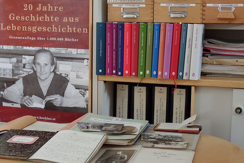 Dokumente, Bücher und ein Plakat zum 20. Jubiläum der Sammlung